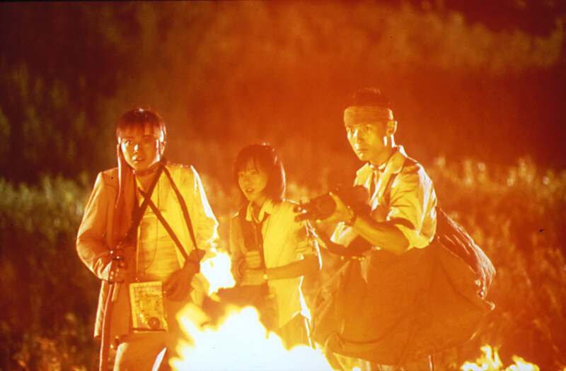 Three people in a fire-lit scene