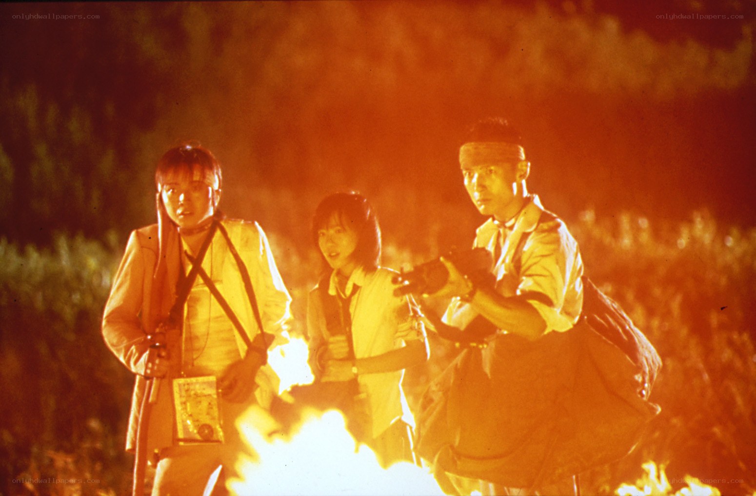 Three people in a fire-lit scene