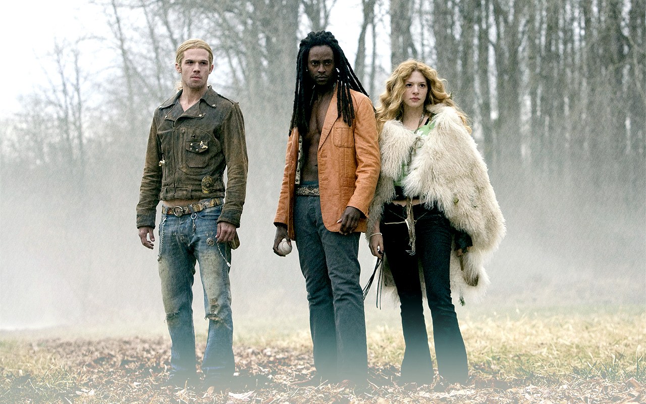 three people in a misty field