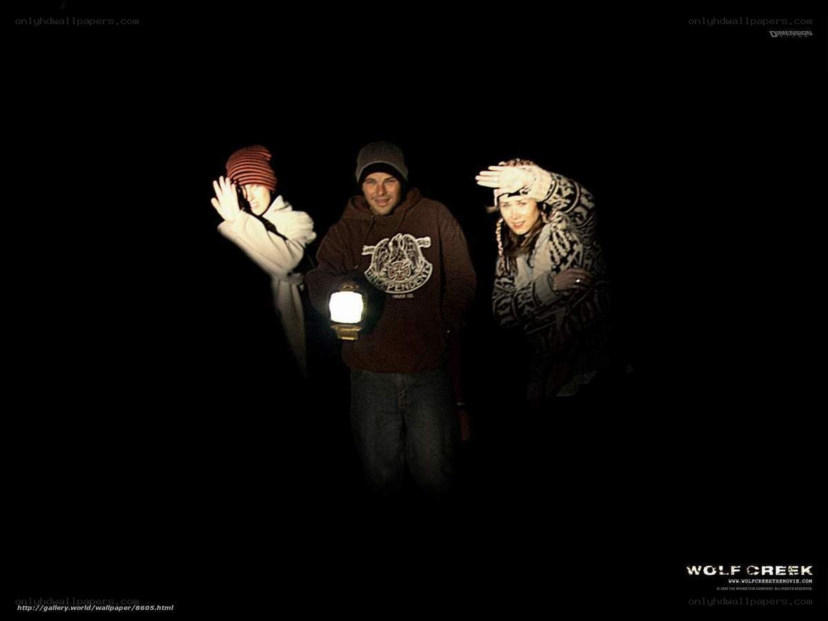 three people in dark with lantern