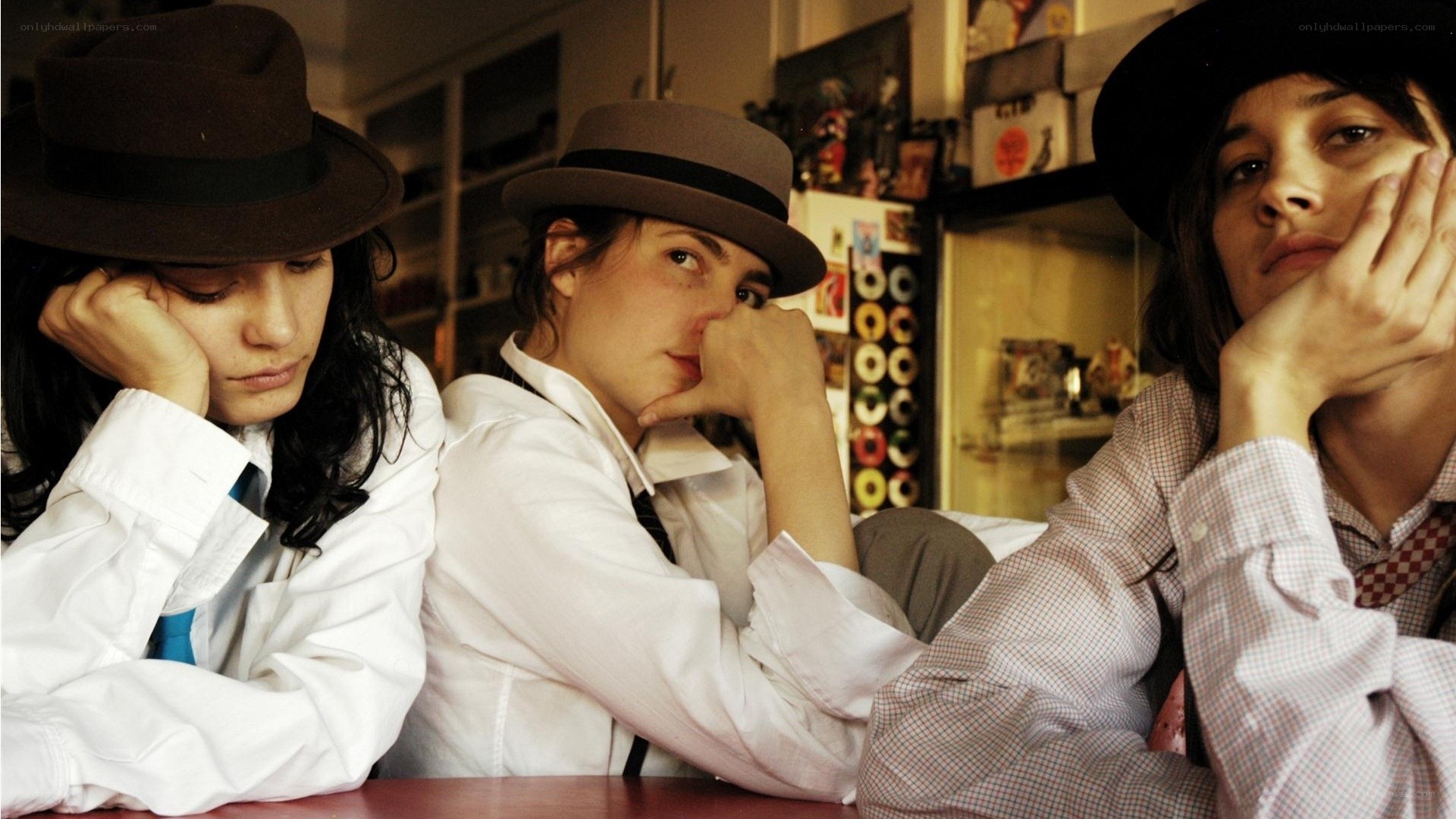 Three people in hats at a table
