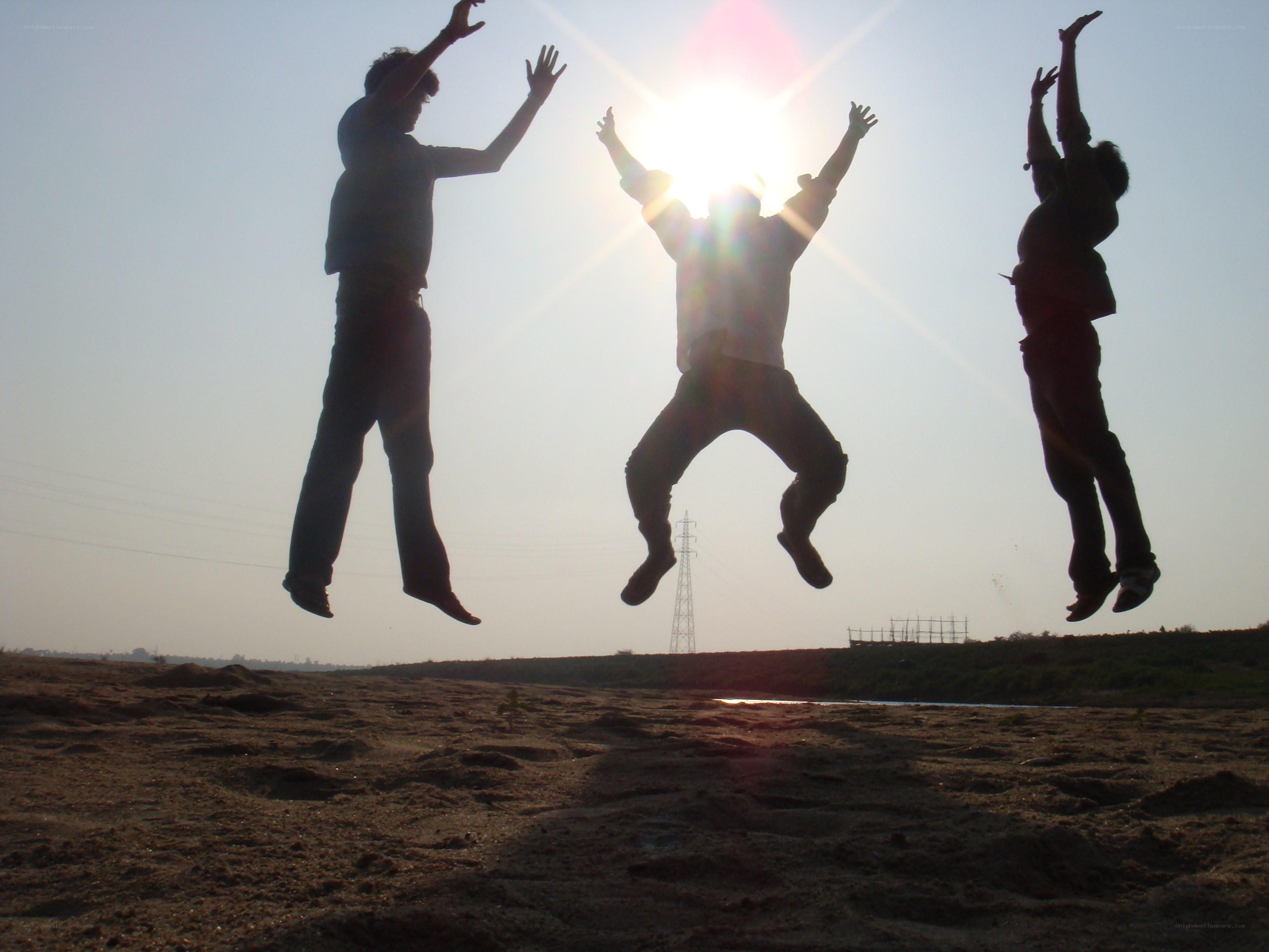 Three people jumping in sun