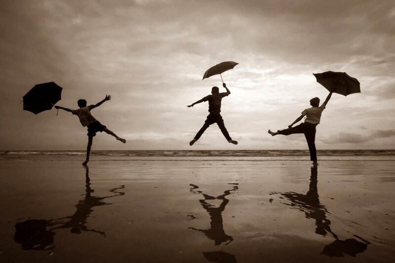 Three People Jumping on Beach