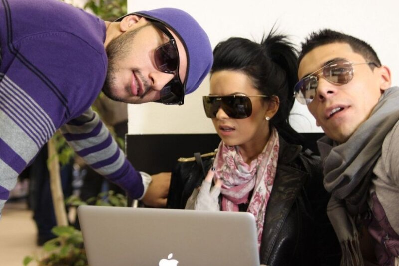 three people looking at laptop