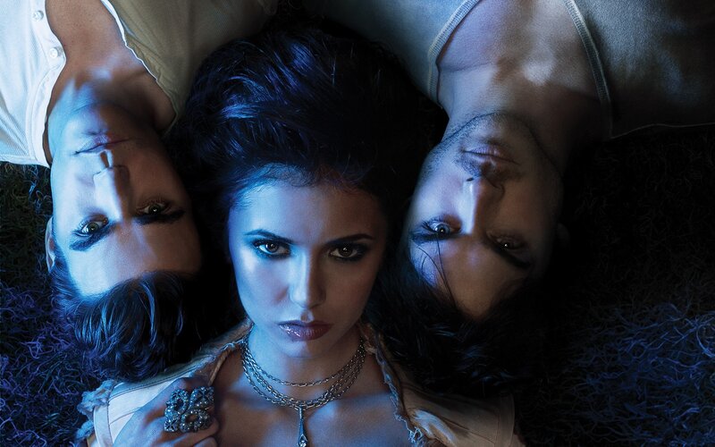 three people lying on grass