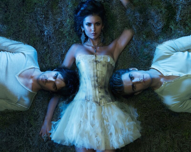 three people lying on grass