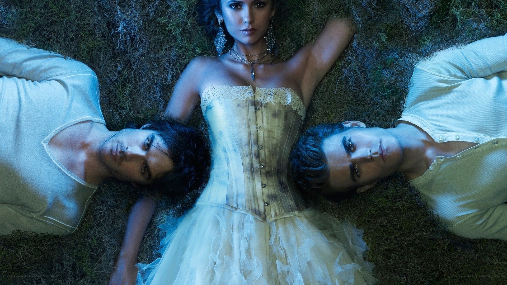three people lying on grass