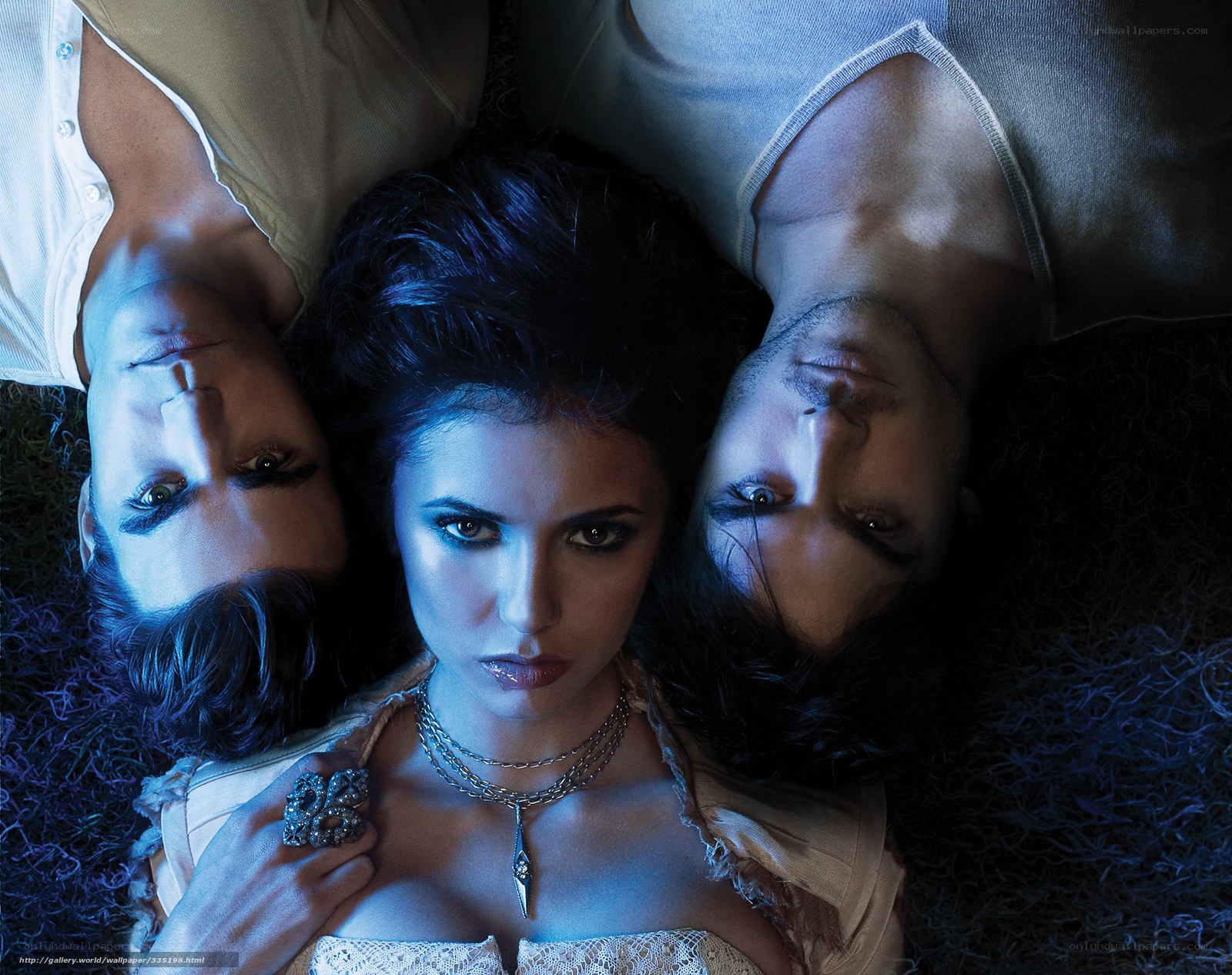 Three people lying on grass