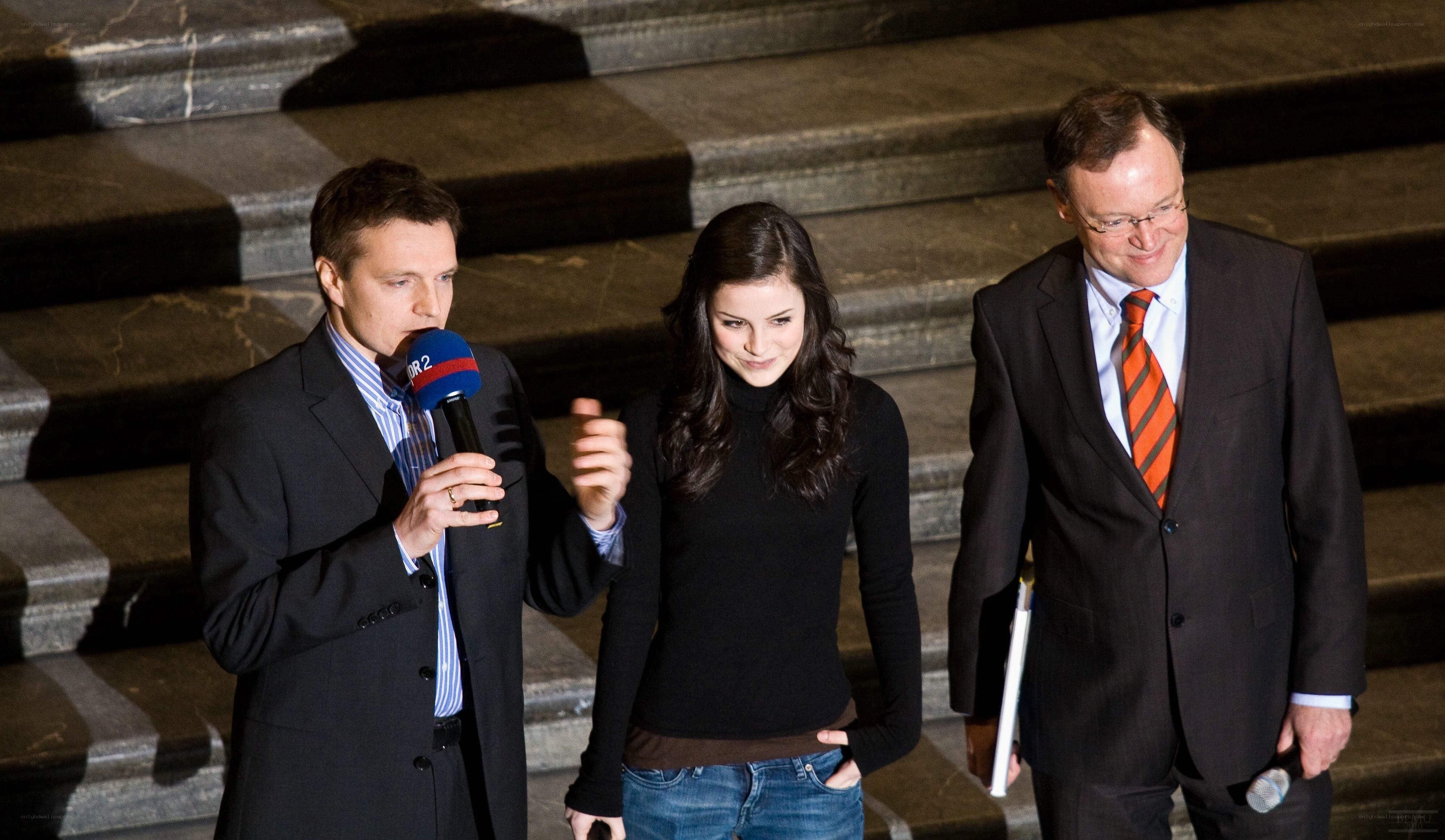 Three people on steps with microphone