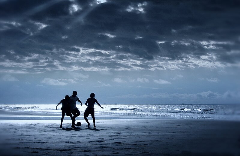 Three People Playing Soccer
