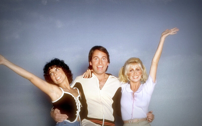 Three people posing with arms raised