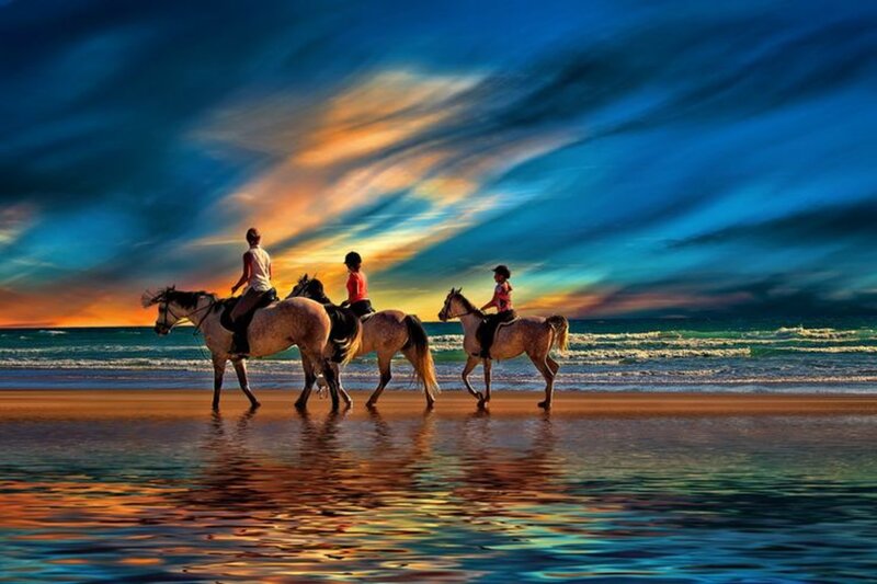 Three People Riding Horses