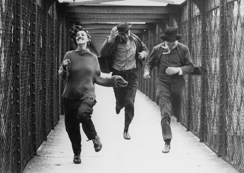 Three people running on a bridge