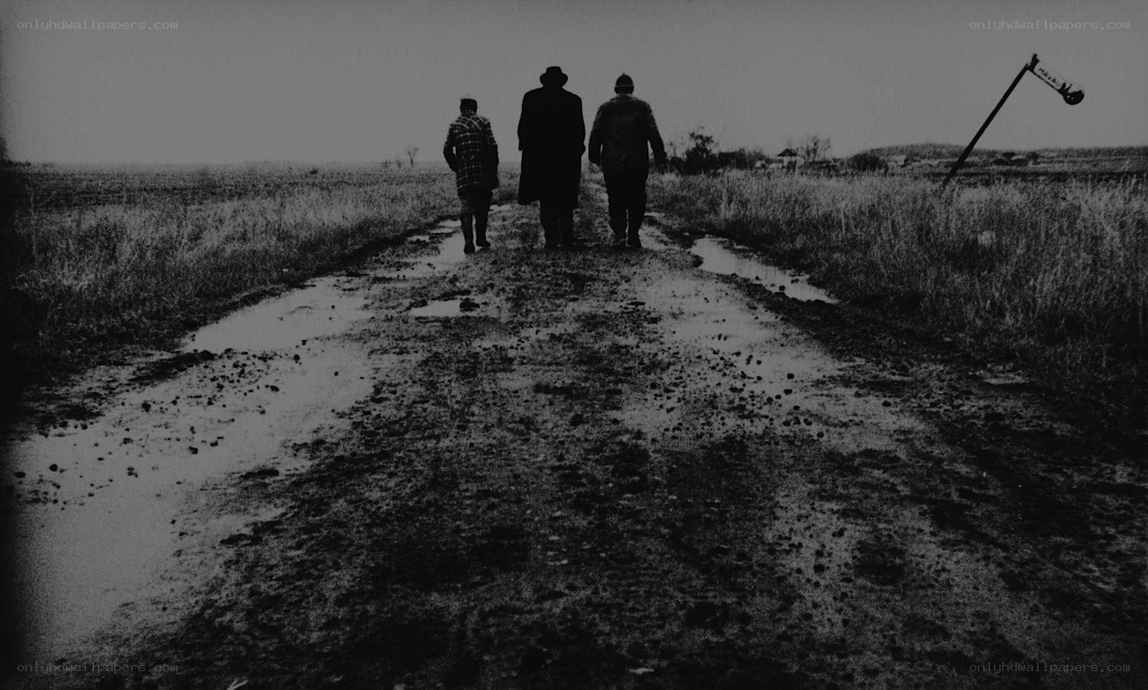 Three people walking on a muddy road