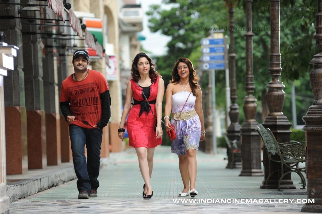 Three people walking on a sidewalk