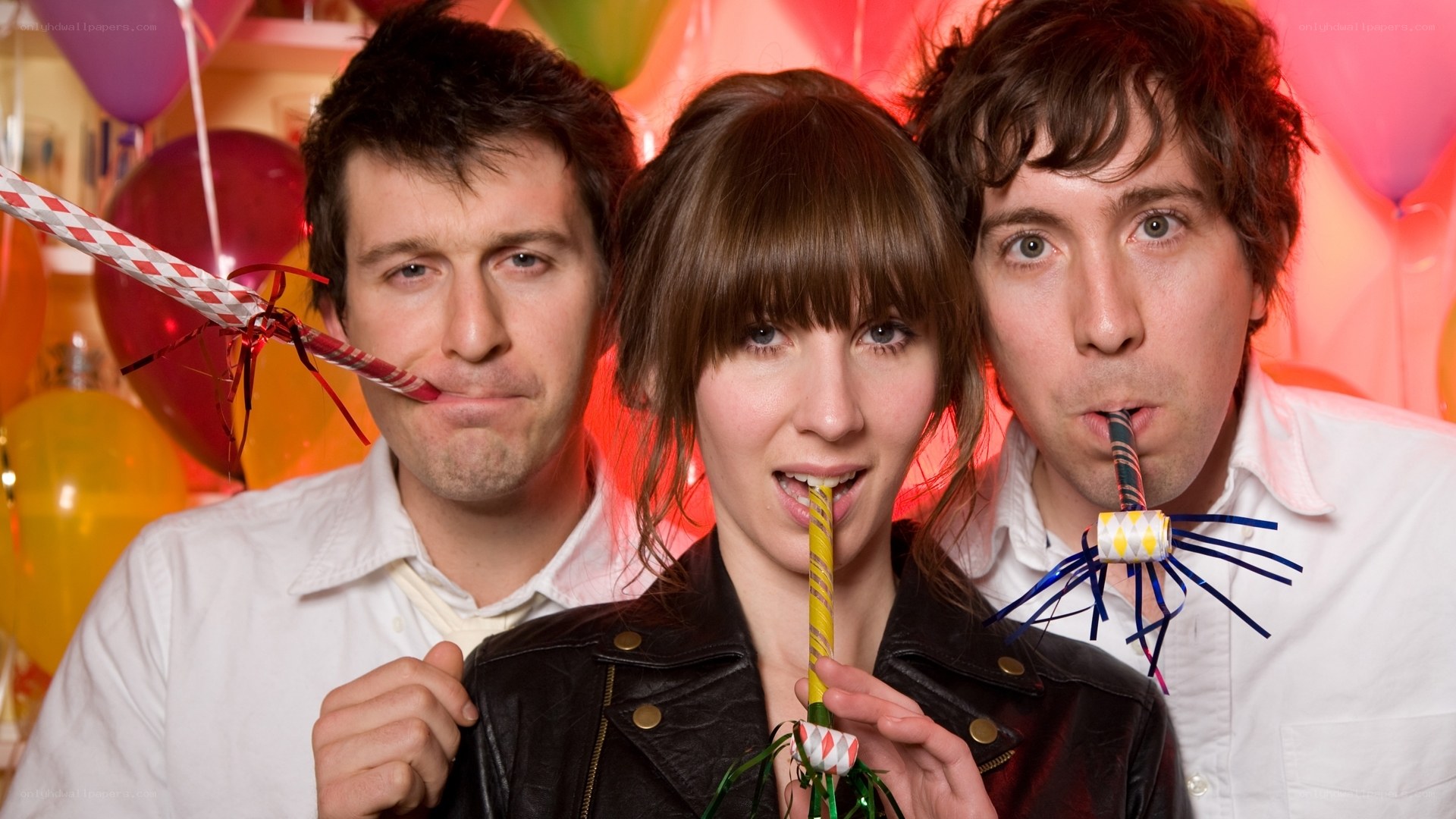 Three people with party blowers