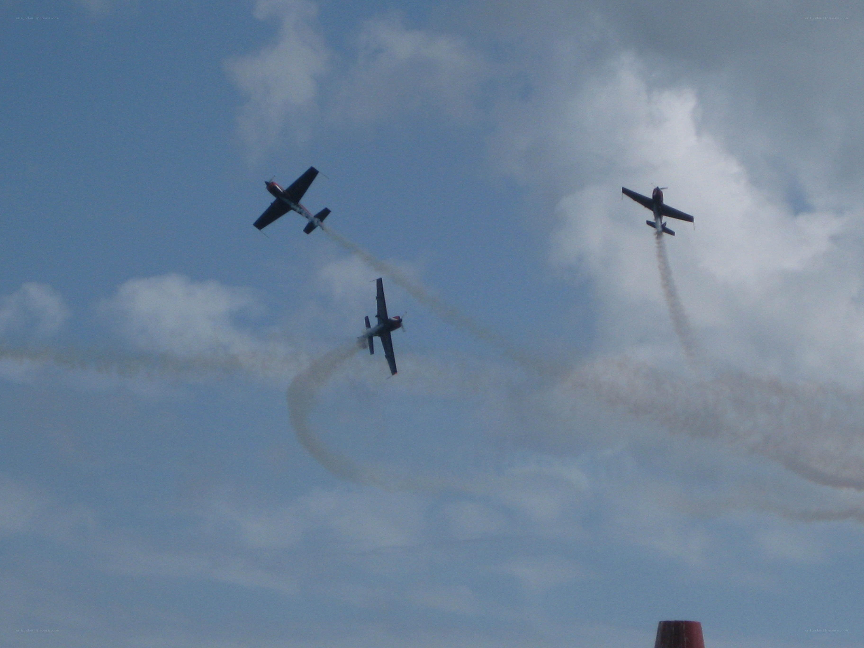 Three planes performing aerobatics