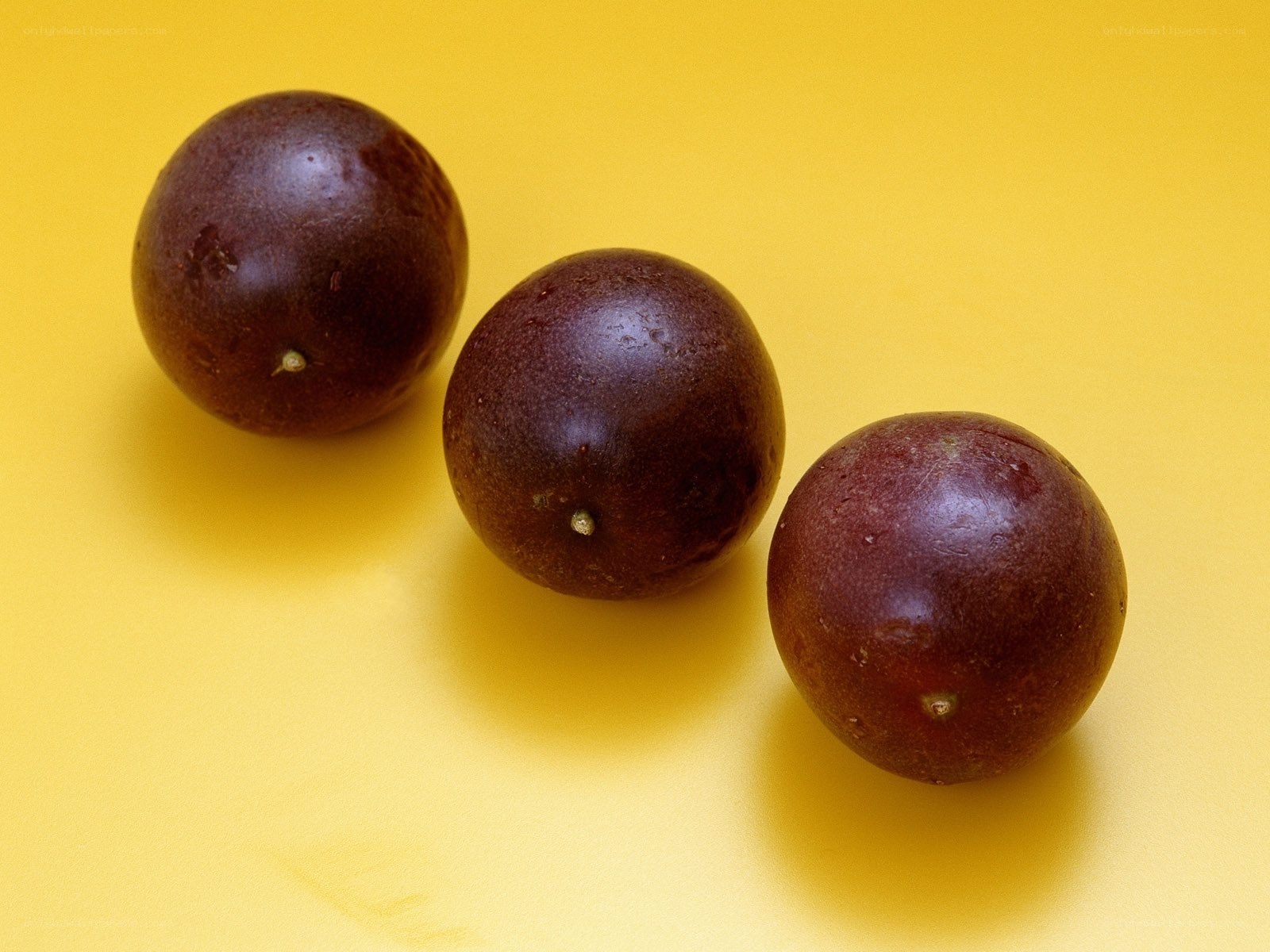 three purple passion fruits
