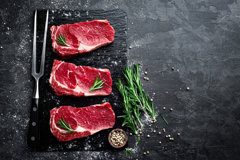 Three Raw Steaks on Slate