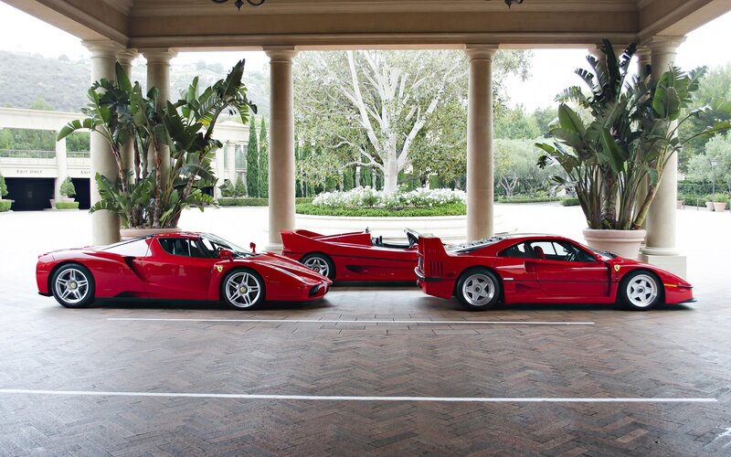 Three red Ferraris in a driveway