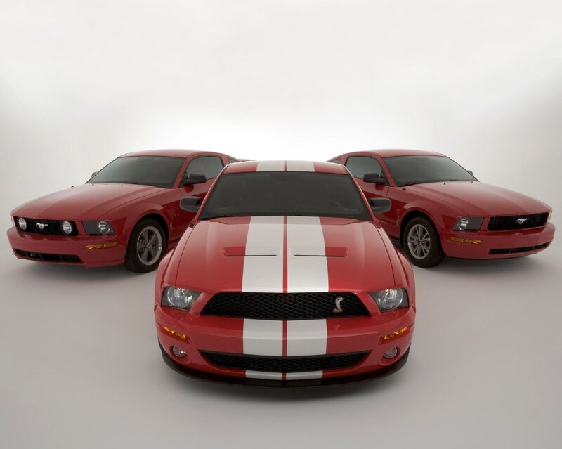 Three red Ford Mustangs