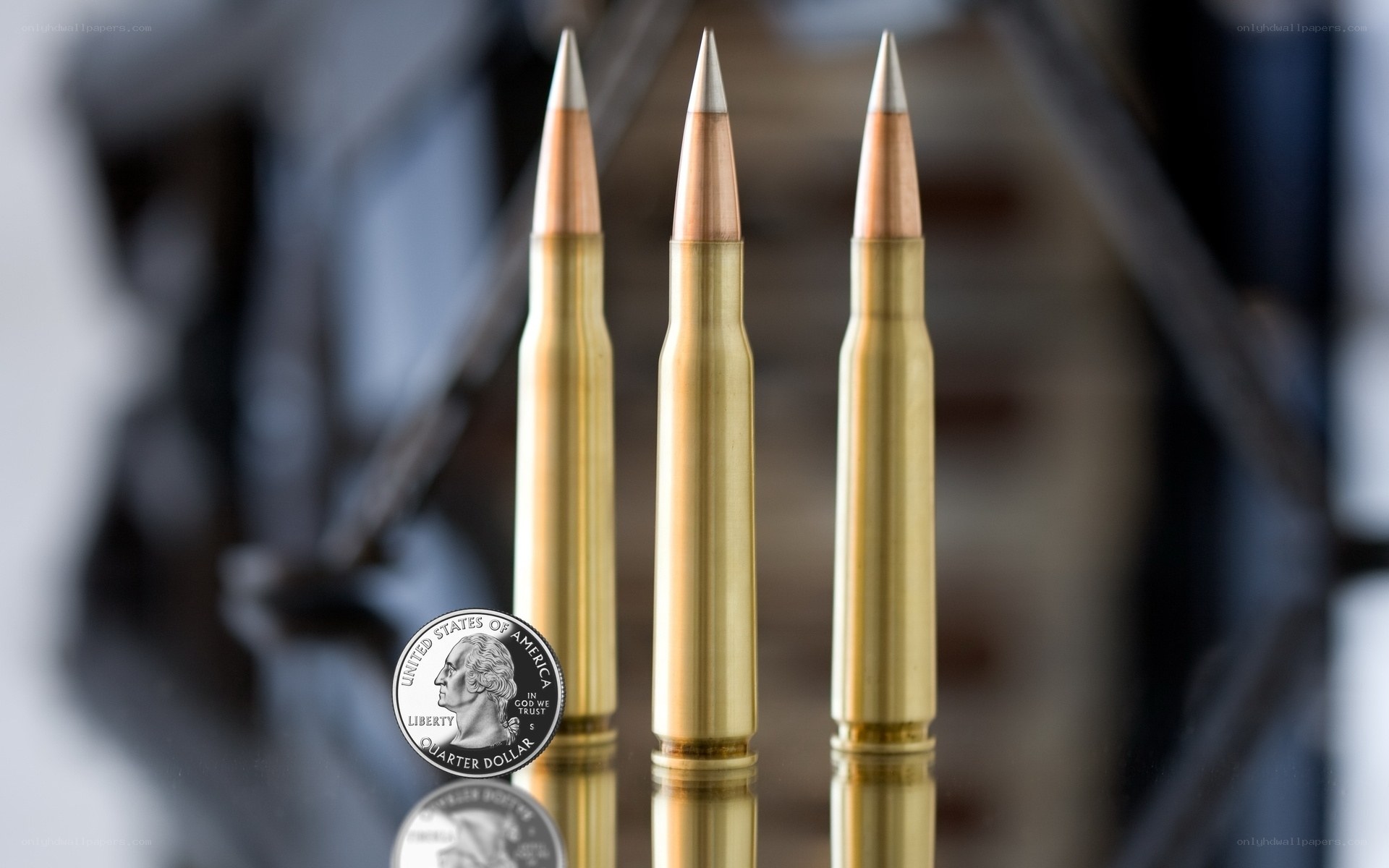 Three rifle bullets with quarter