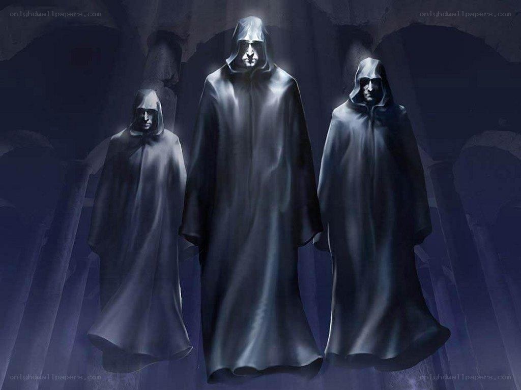 three robed figures in a cave