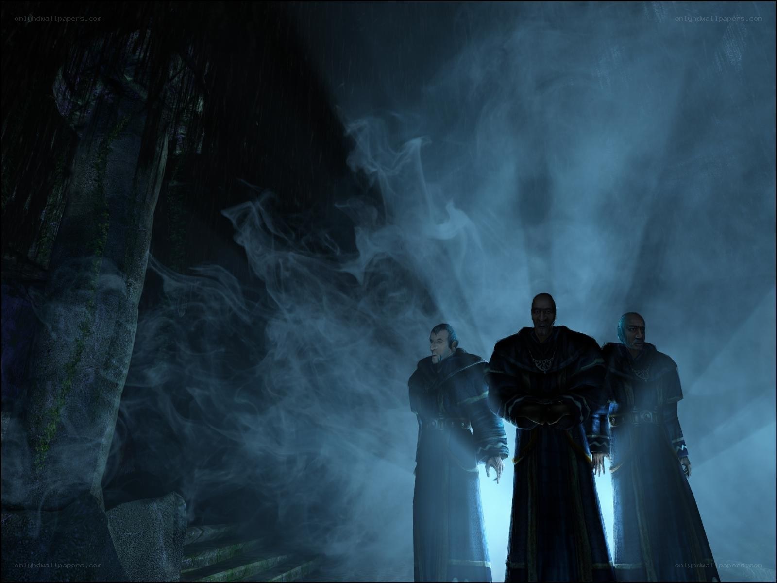 Three robed figures in a misty cave