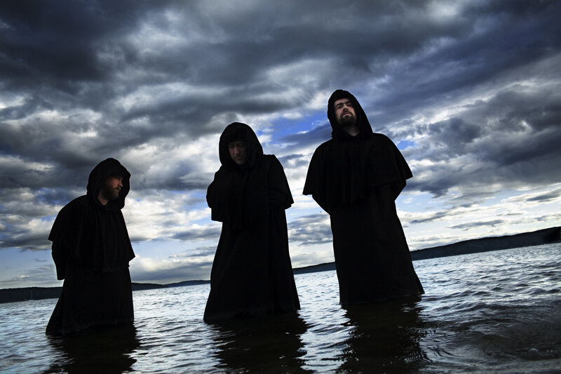 Three robed figures in water