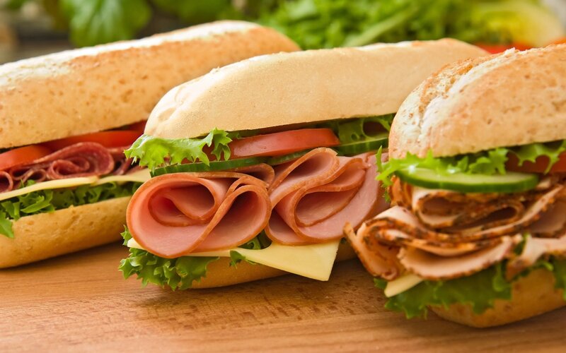 Three sandwiches on a wooden board