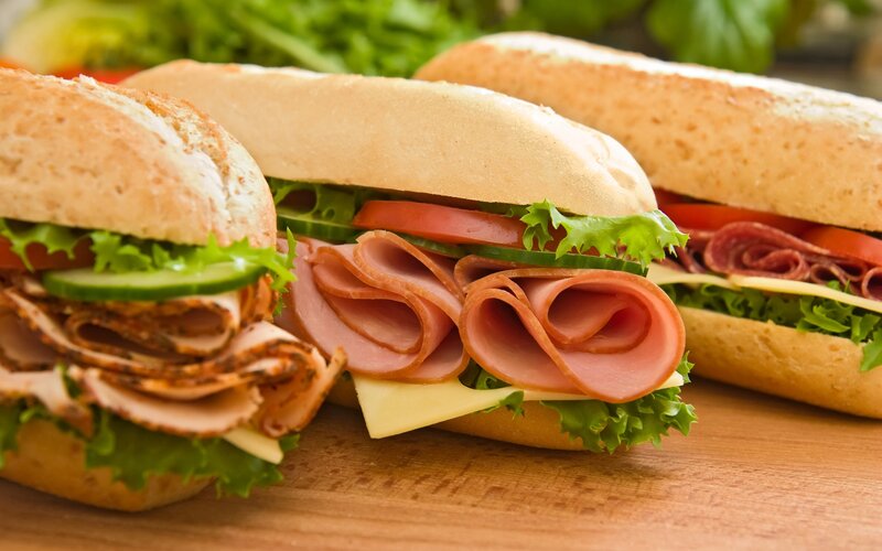 Three sandwiches on a wooden board