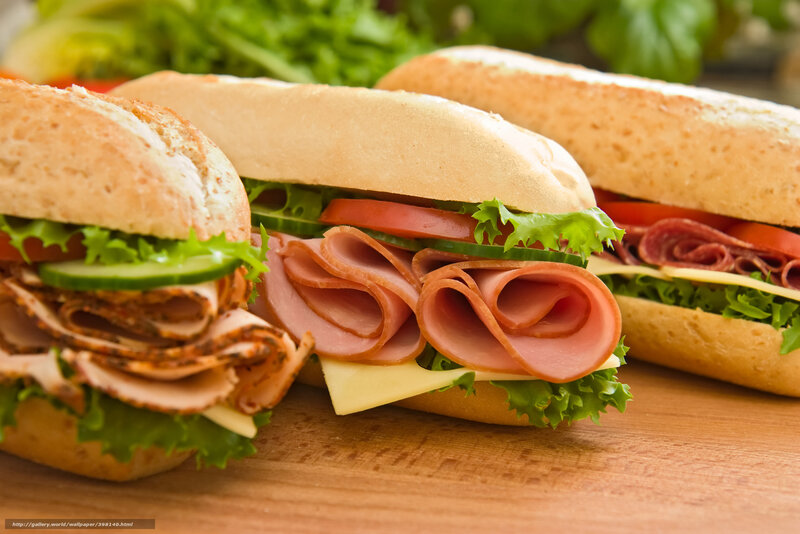 Three sandwiches on a wooden board