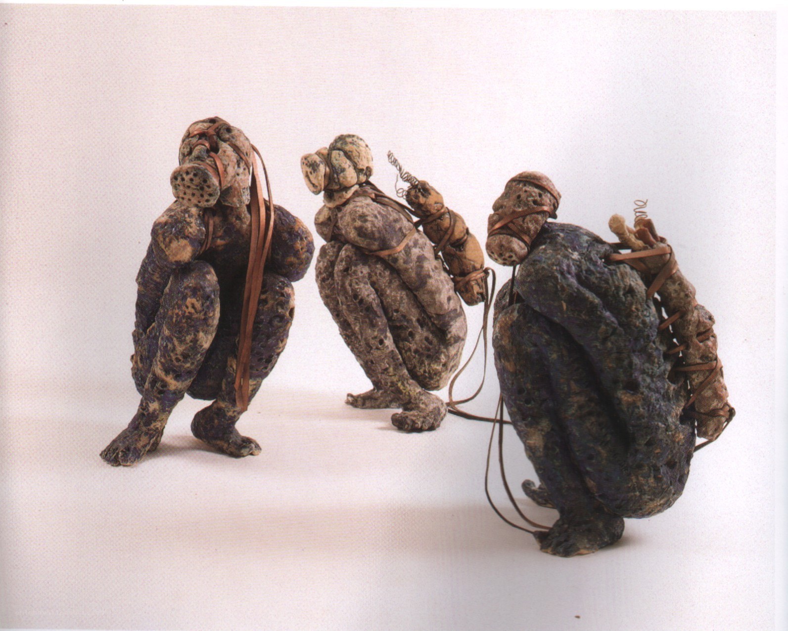 Three sculpted figures in crouched poses