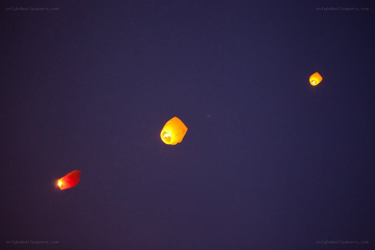 Three sky lanterns at night
