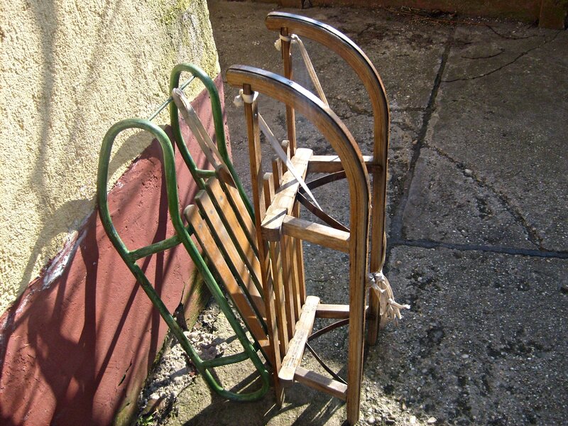 Three Sleds Leaning Against Wall