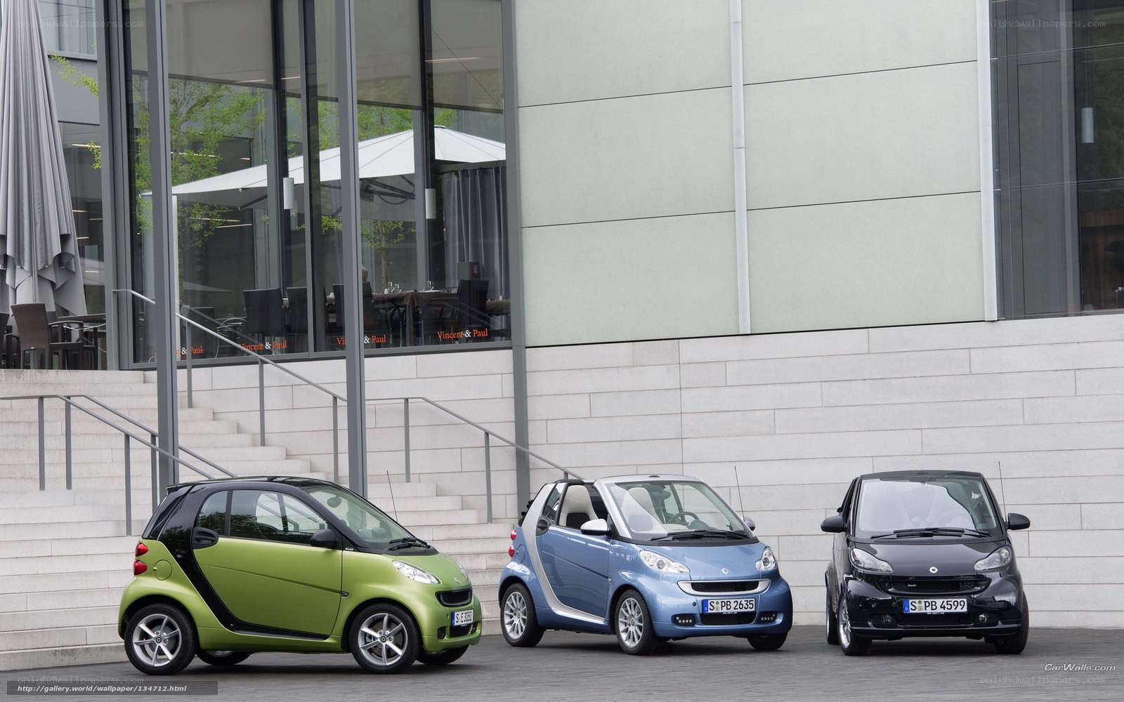 Three Smart cars parked outside