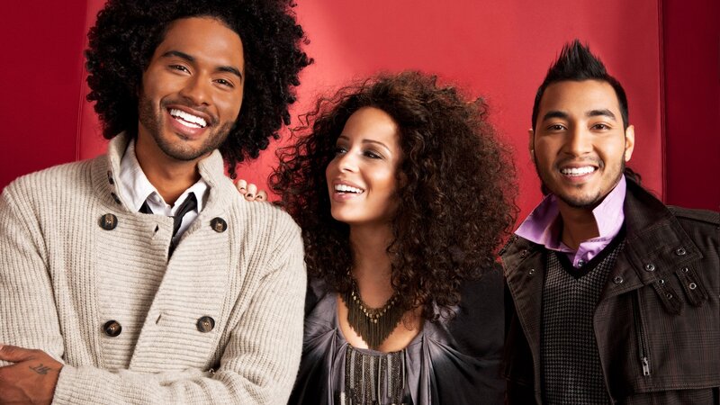 three smiling people in studio