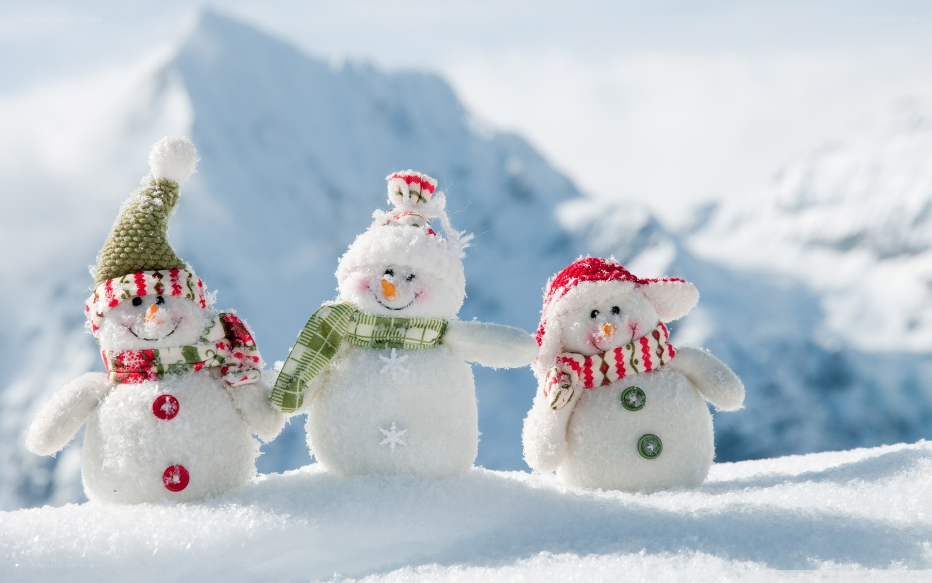Three snowmen in snowy mountains