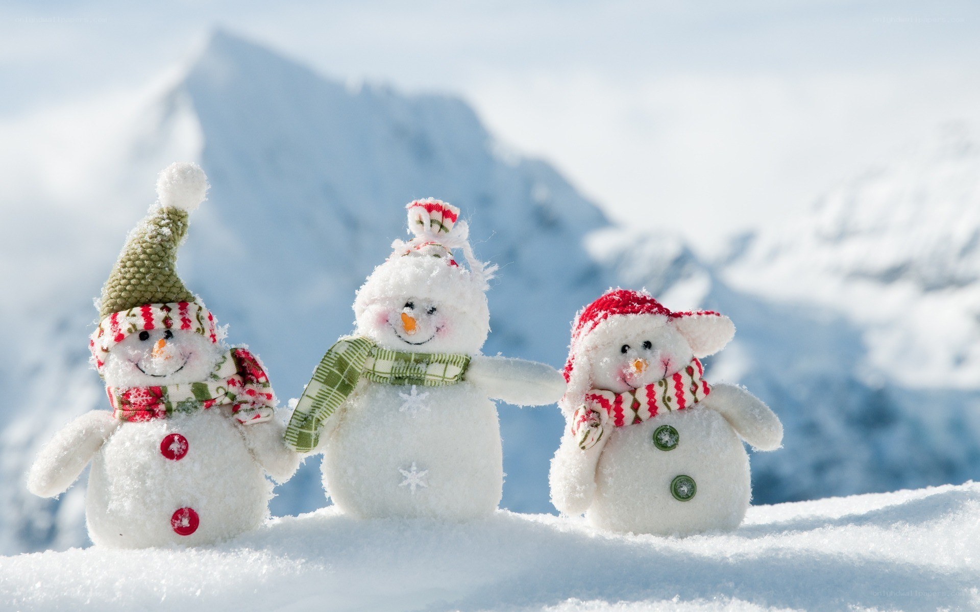 Three snowmen in snowy mountains