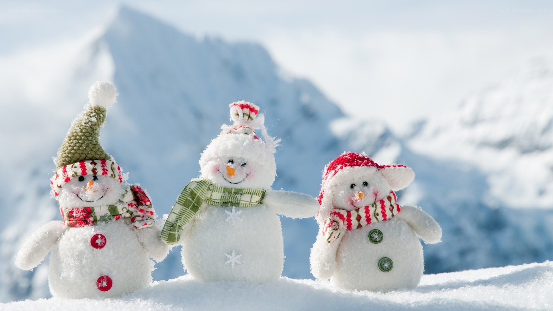Three snowmen in snowy mountains
