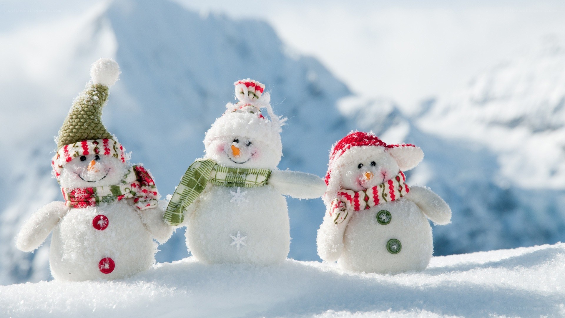 Three snowmen in snowy mountains