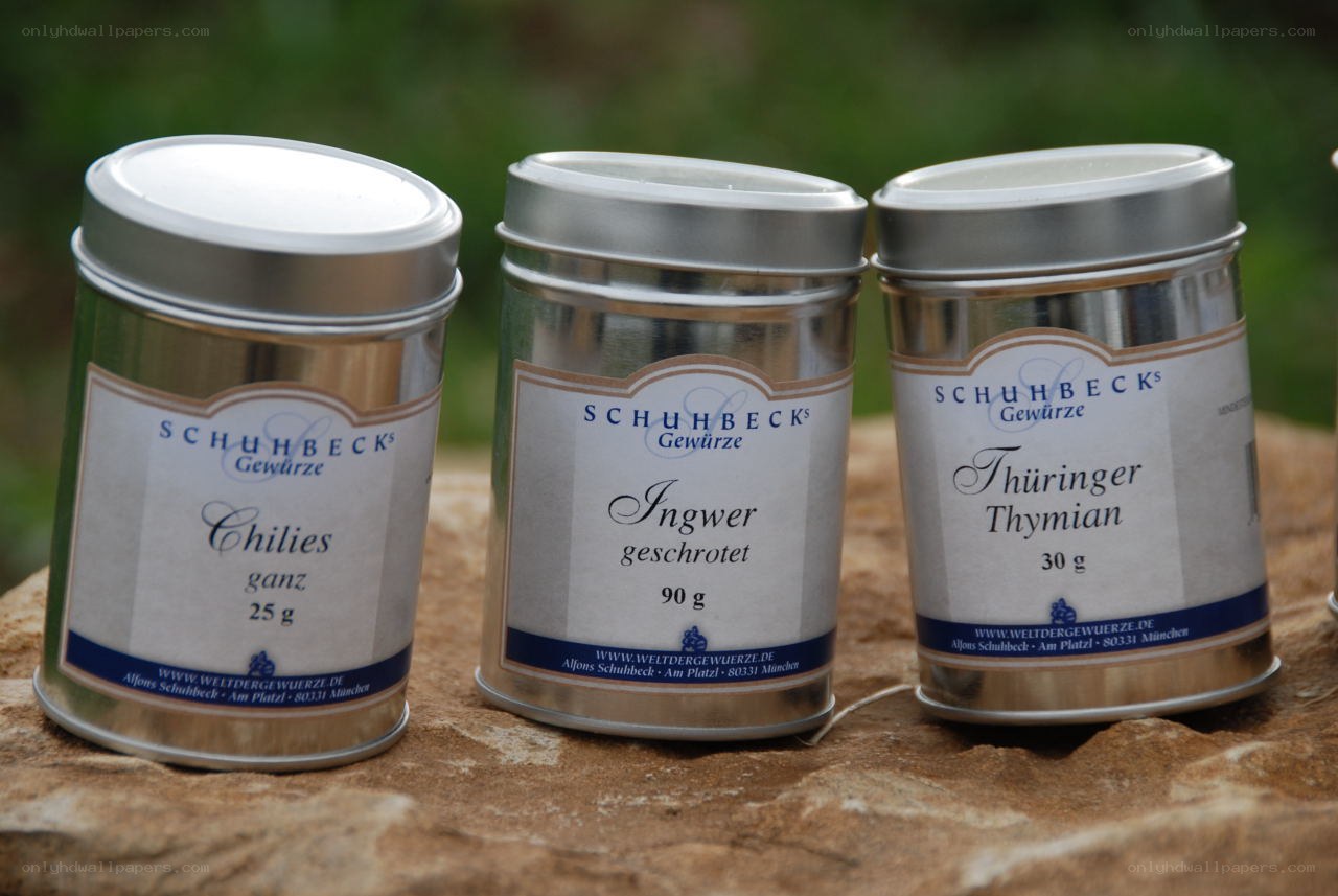Three spice tins on a stone surface