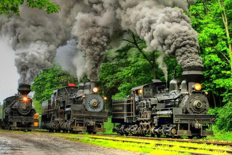 Three steam trains on tracks