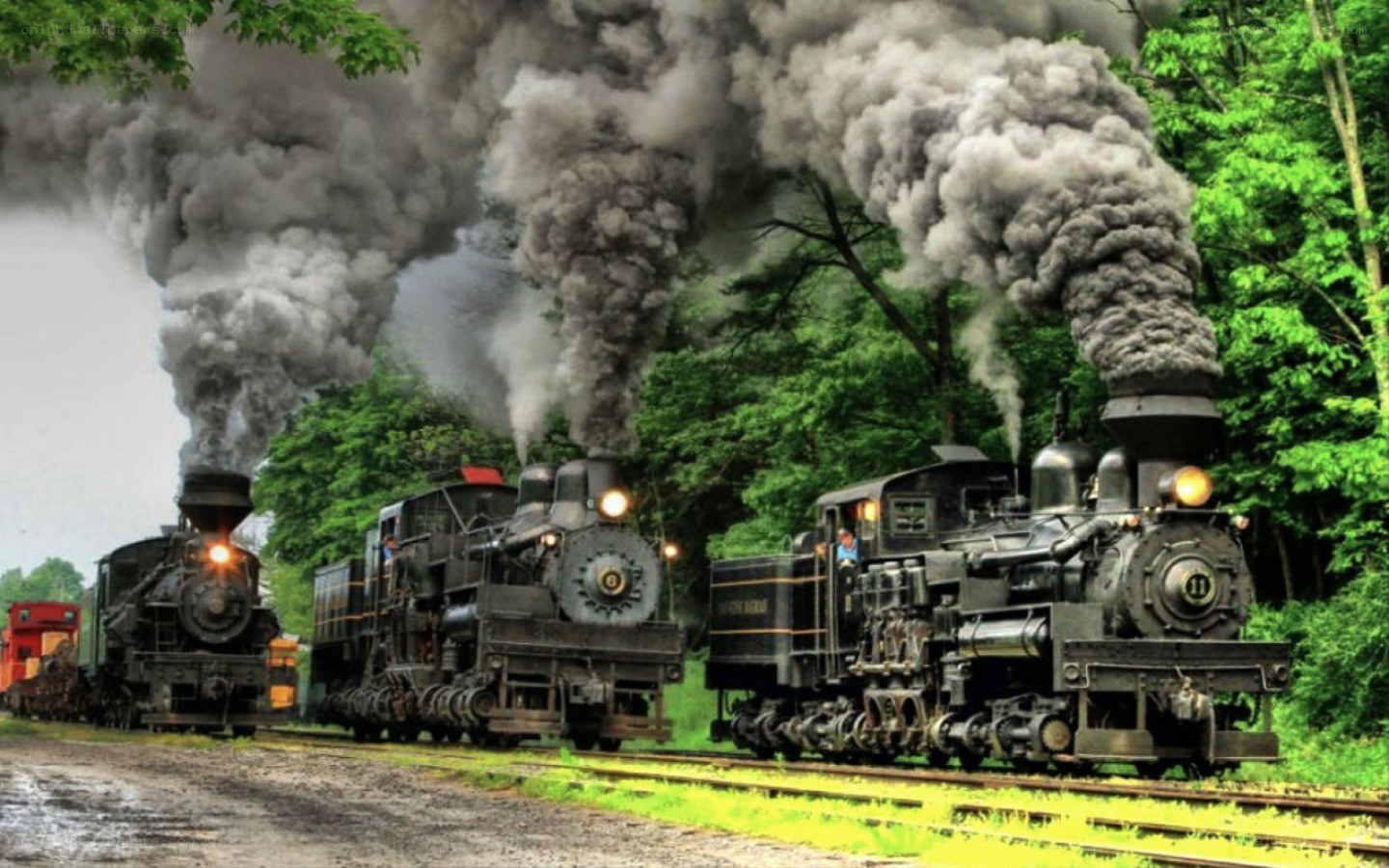 Three steam trains on tracks