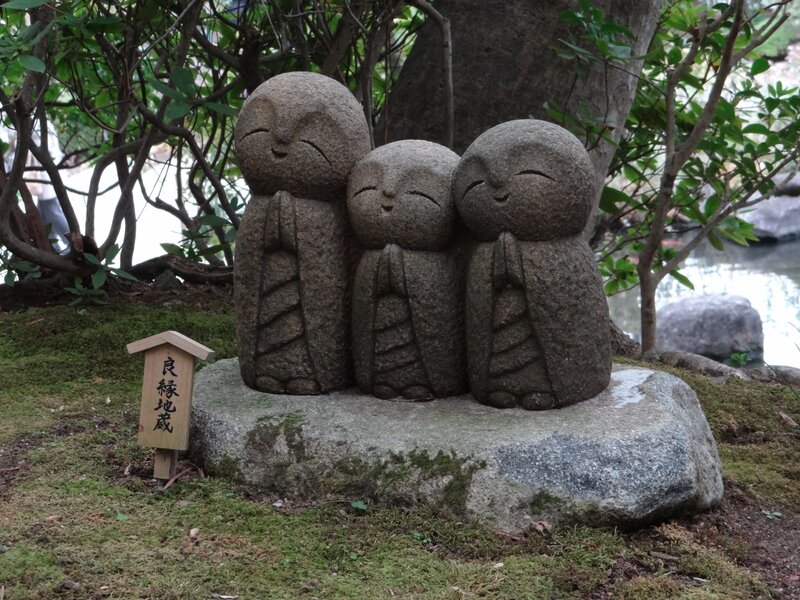 Three stone monk statues in garden