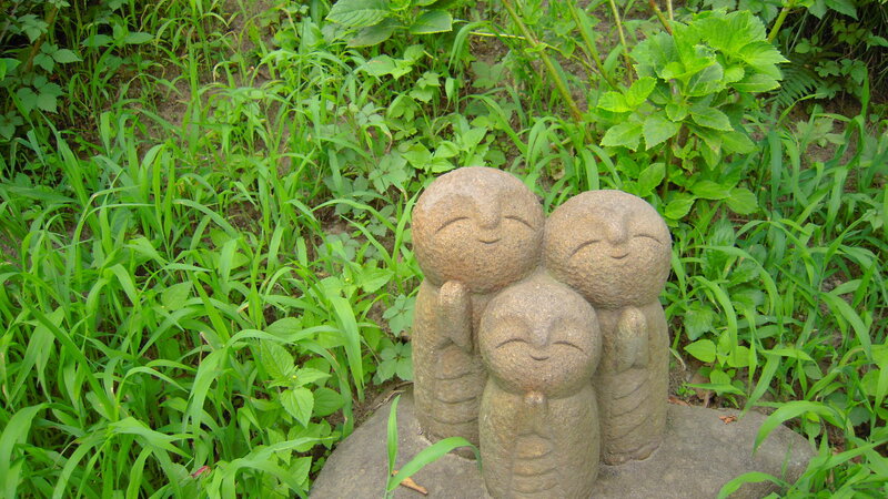 Three Stone Statues in Grass