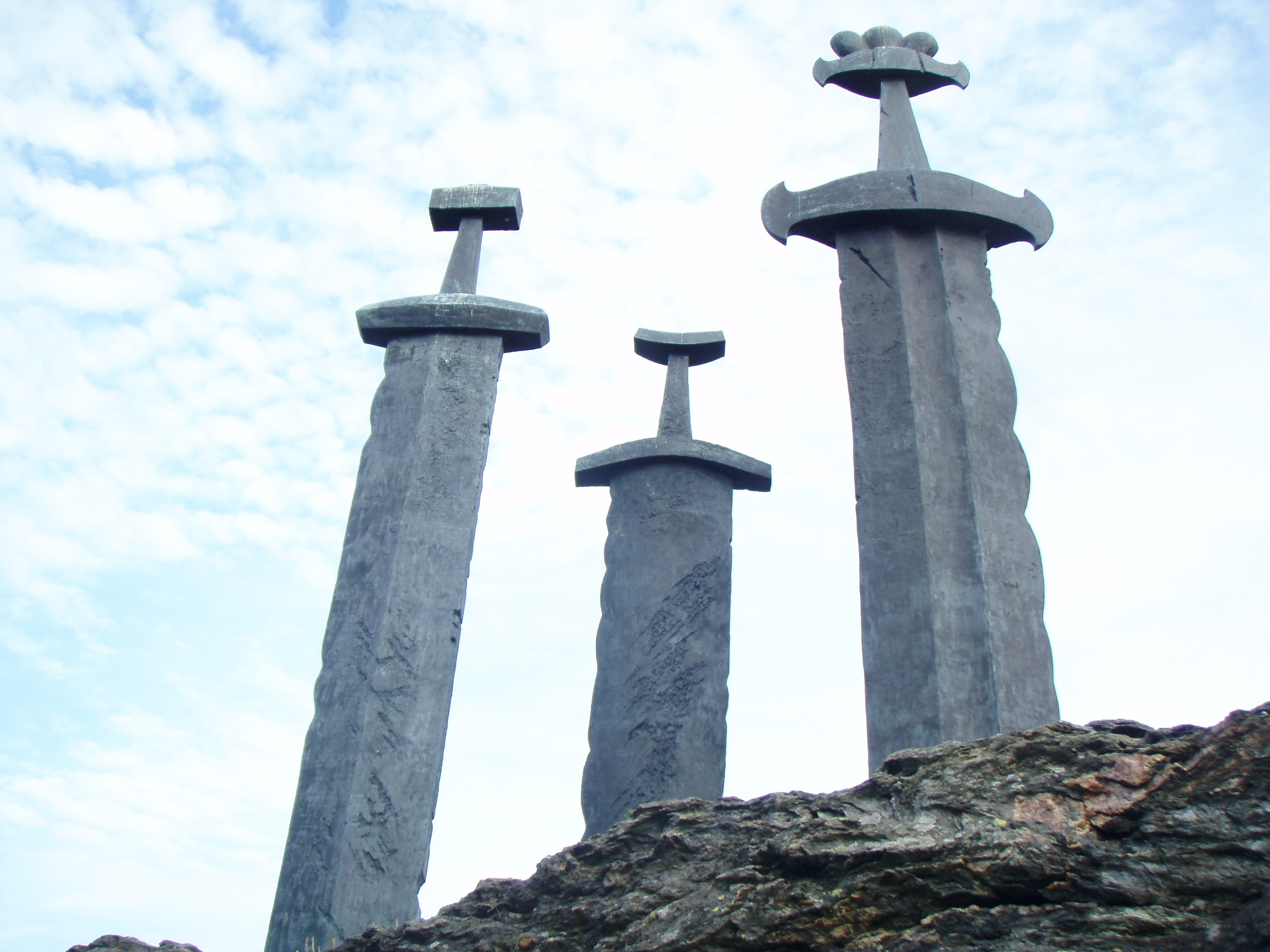 Three swords on a rocky outcrop