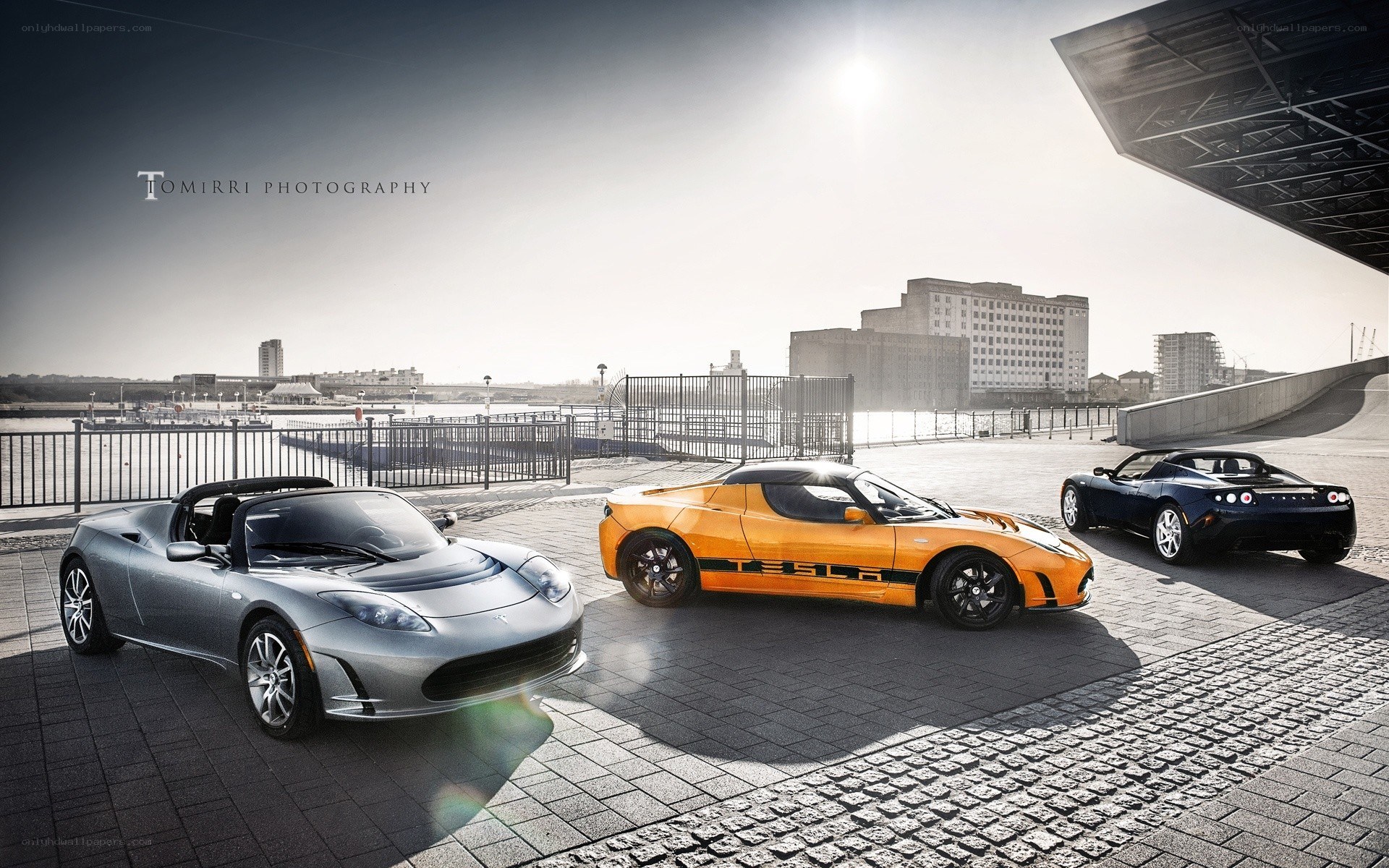 Three Tesla Roadsters on a pier