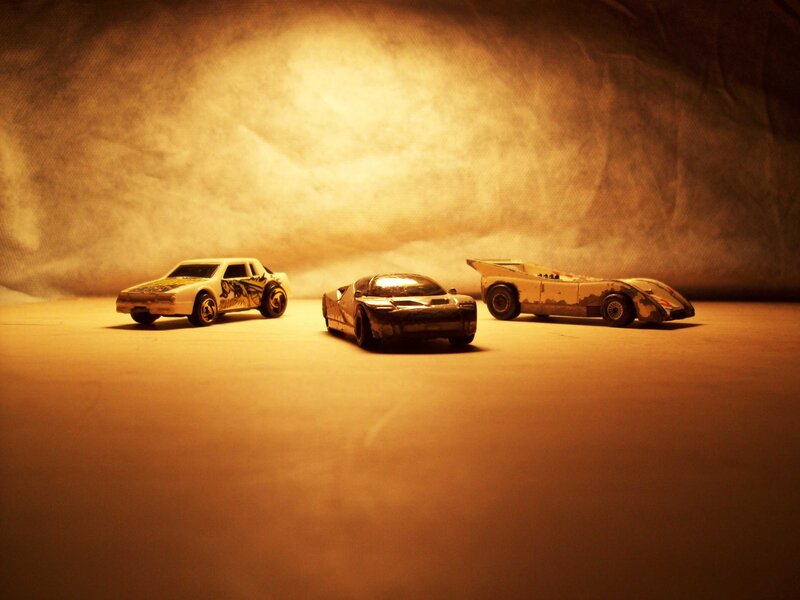 Three toy cars in warm light