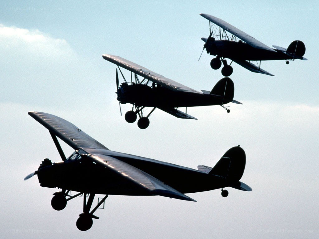 Three vintage biplanes in flight